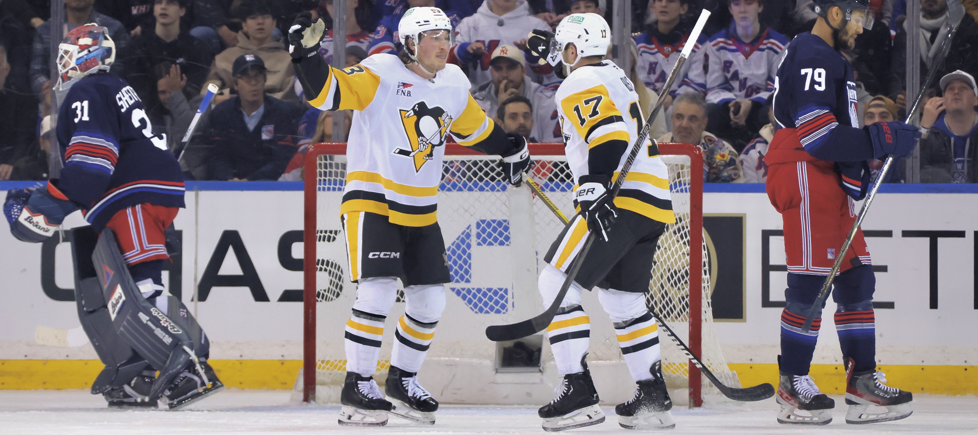 Phil Tomasino and Bryan Rust celebrate the former's goal Friday night in New York.