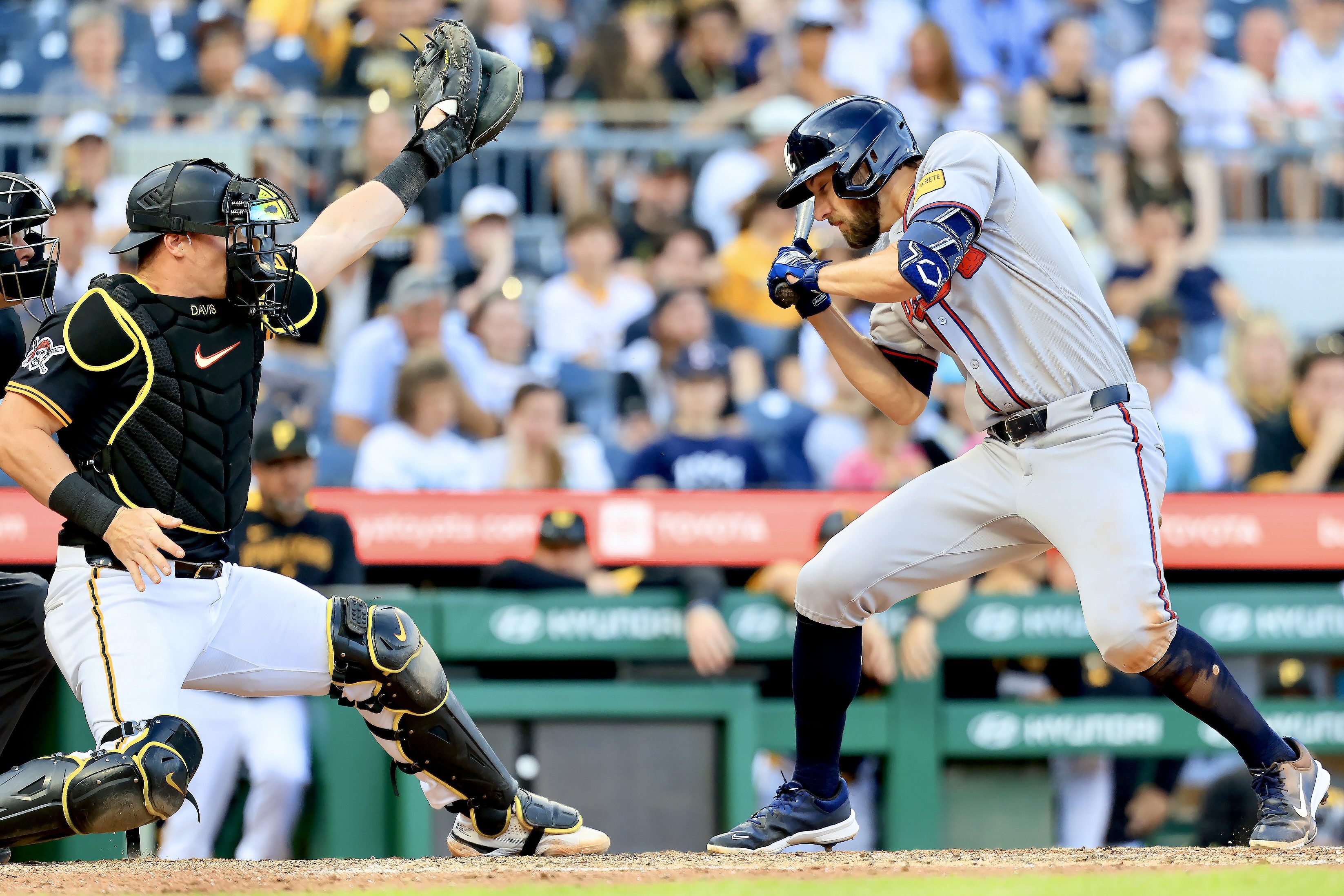 Henry Davis can't catch a run-scoring wild pitch that sails by the Braves' Eli White in the 11th inning.