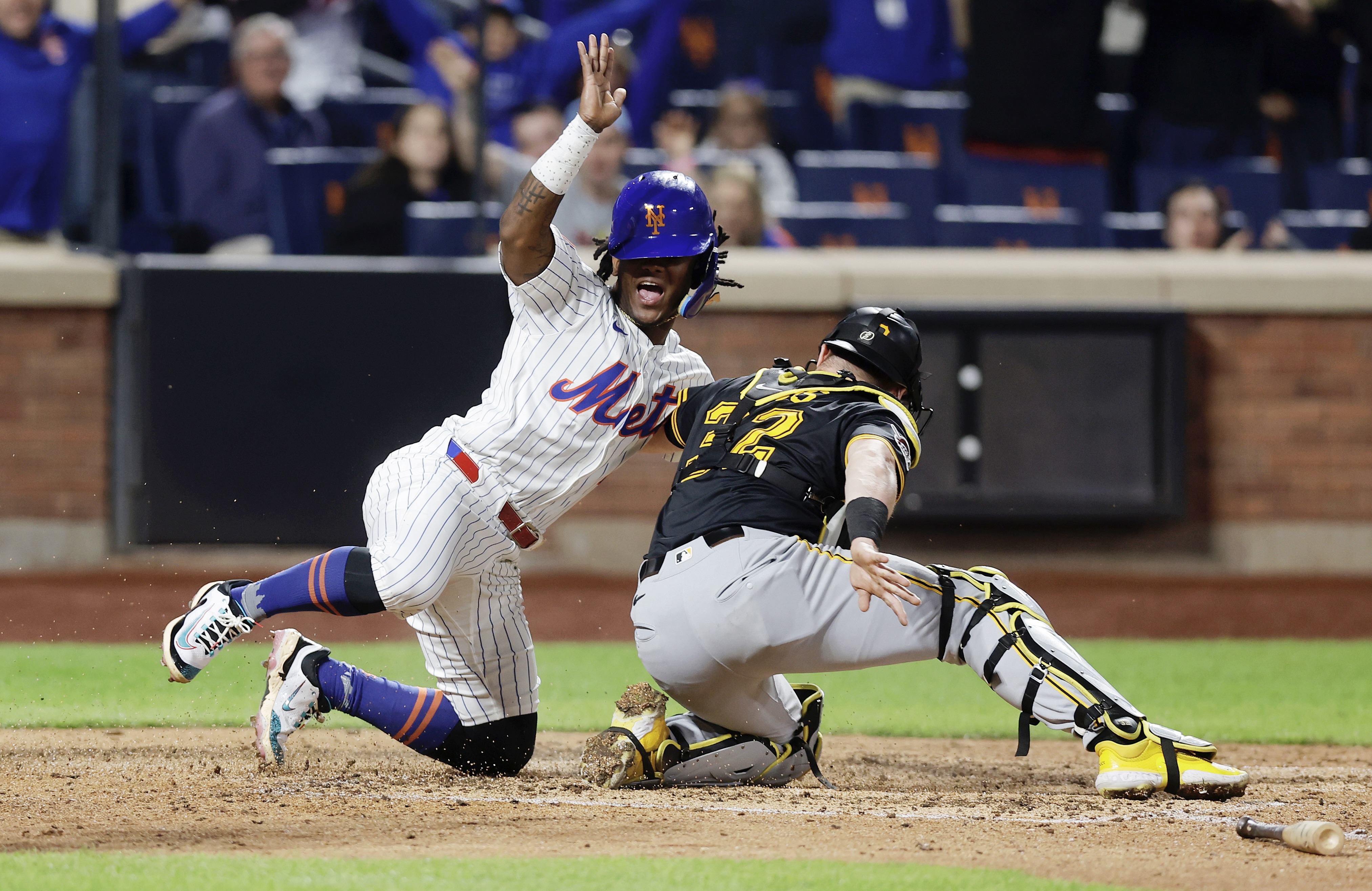 The Mets' Luisangel Acuña slides under Henry Davis' tag for a run in the seventh inning Monday night in New York.
