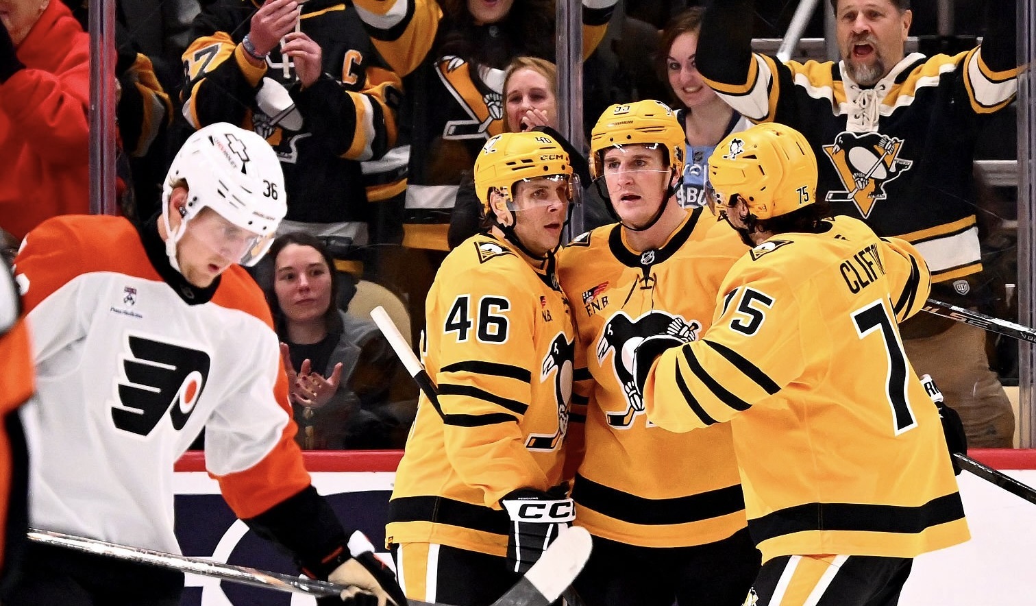 Blake Lizotte and Connor Clifton congratulate Noel Acciari on his second-period goal Thursday night at PPG Paints Arena.
