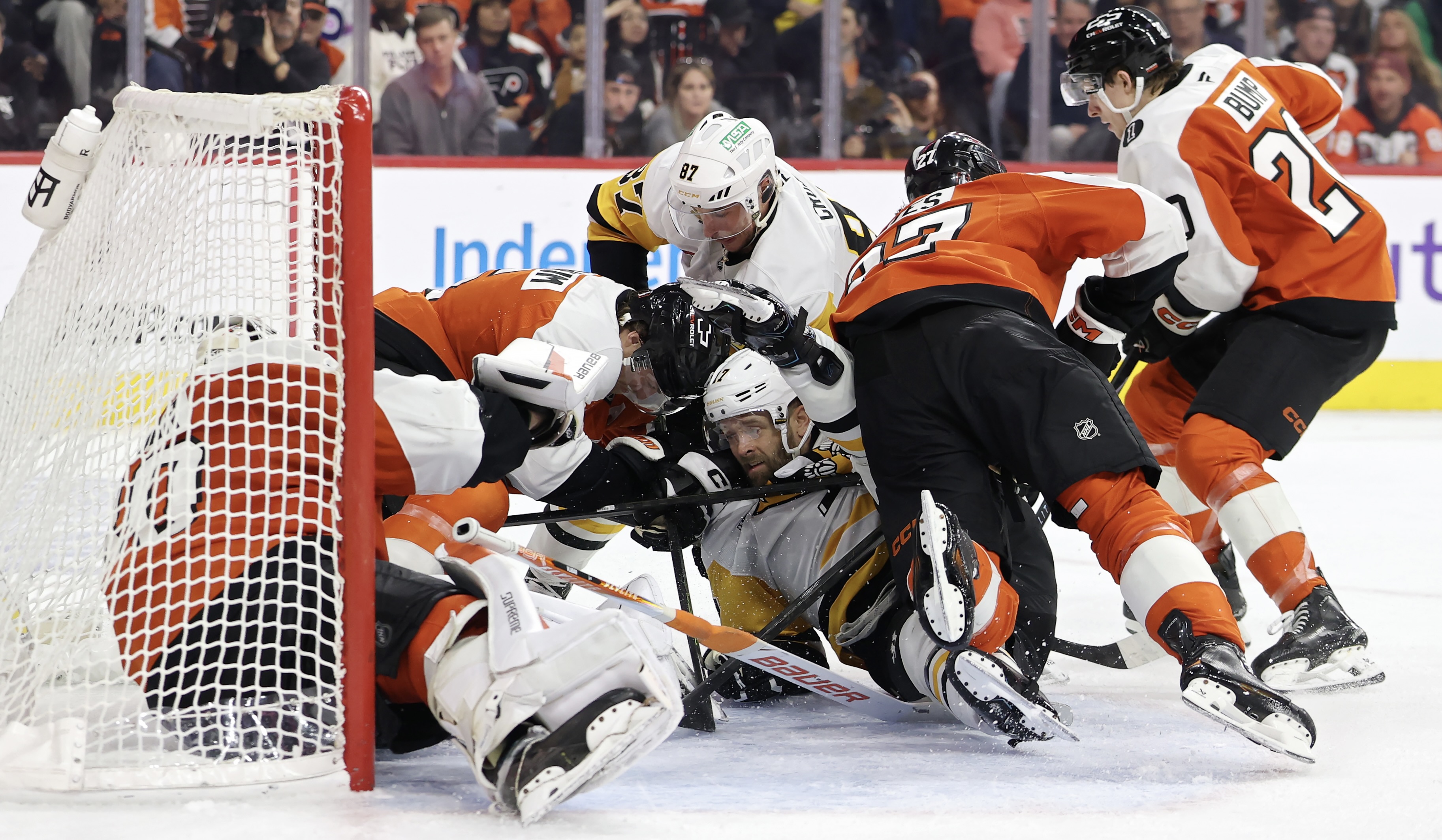 Sidney Crosby and Bryan Rust crash the crease of the Flyers' Dan Vladar in the third period.