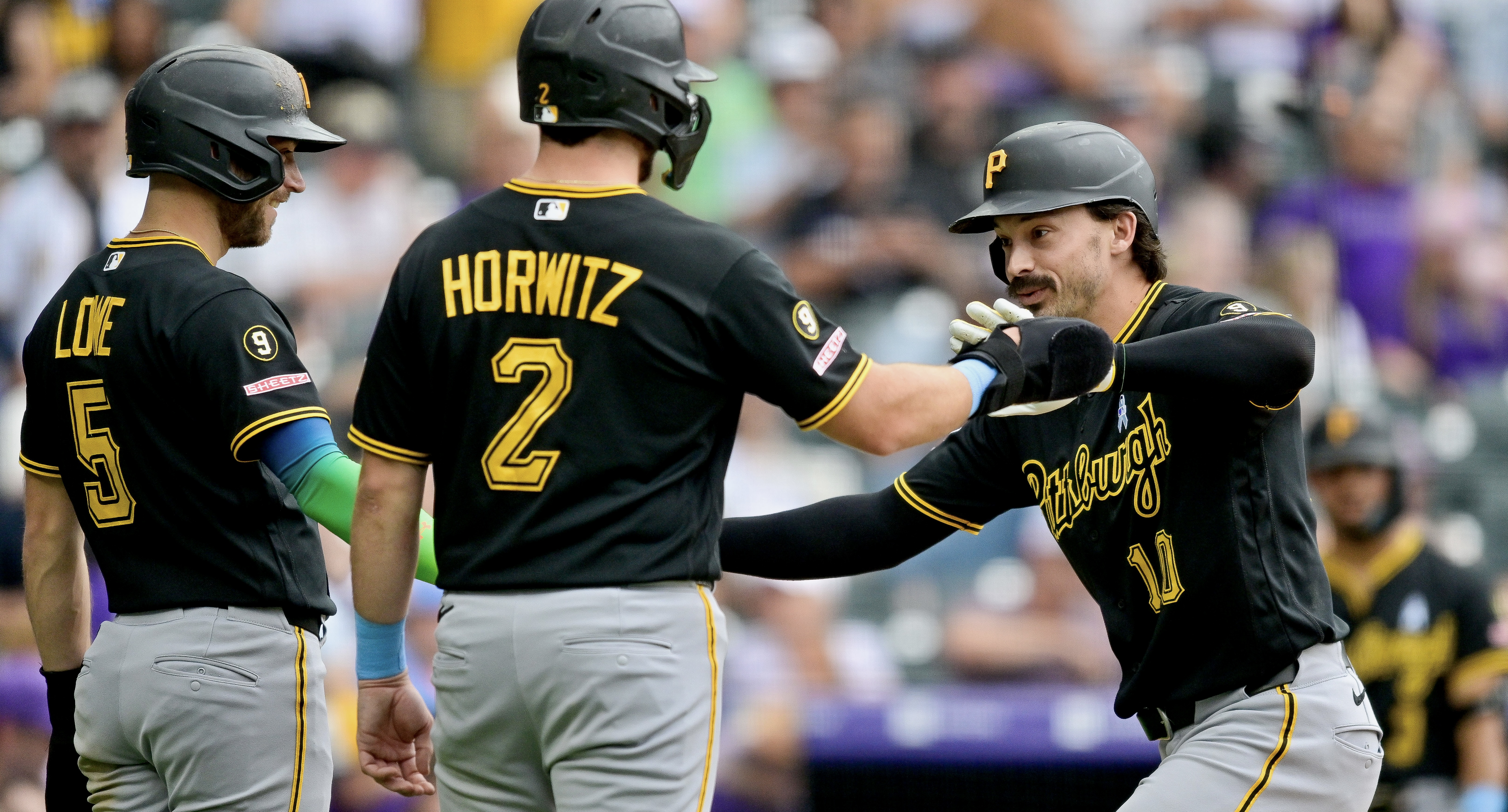 Bryan Reynolds gets welcomed after his three-run home run in the seventh inning Sunday in Denver.