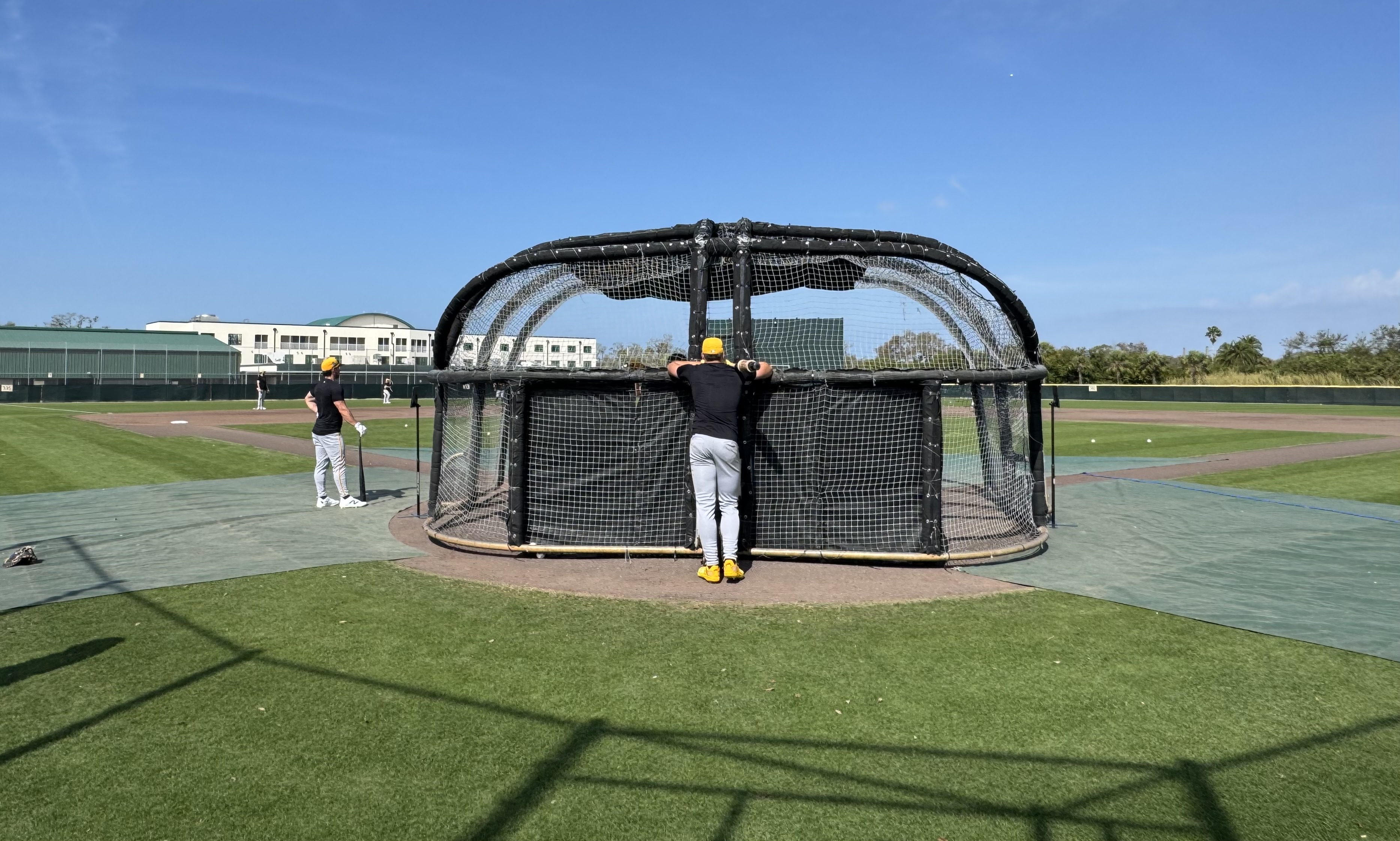 Konnor Griffin chills behind a batting cage.
