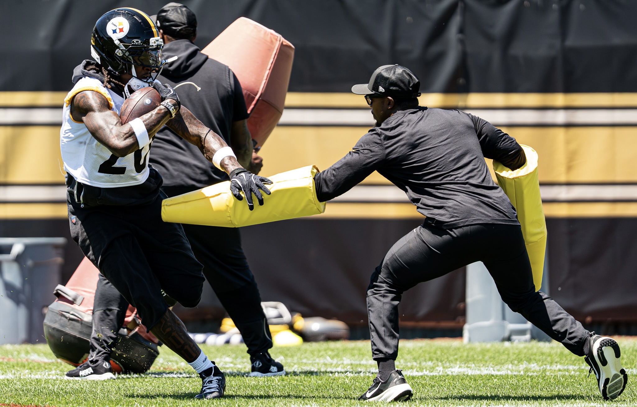 Kaleb Johnson stiff-arms a pad held by a team staffer Wednesday on the South Side.