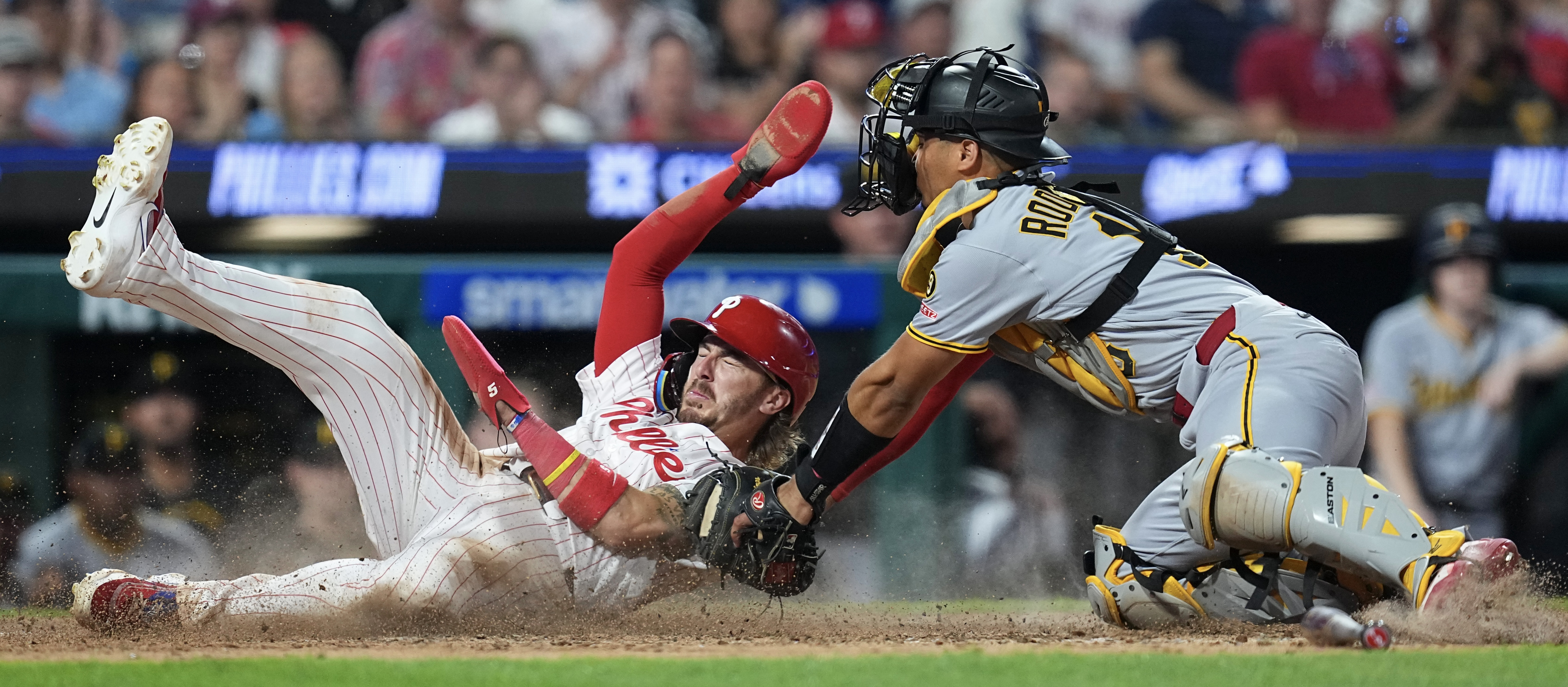 The Phillies' Bryson Stott slides safely past Endy Rodríguez in the eighth inning Tuesday night in Philadelphia.