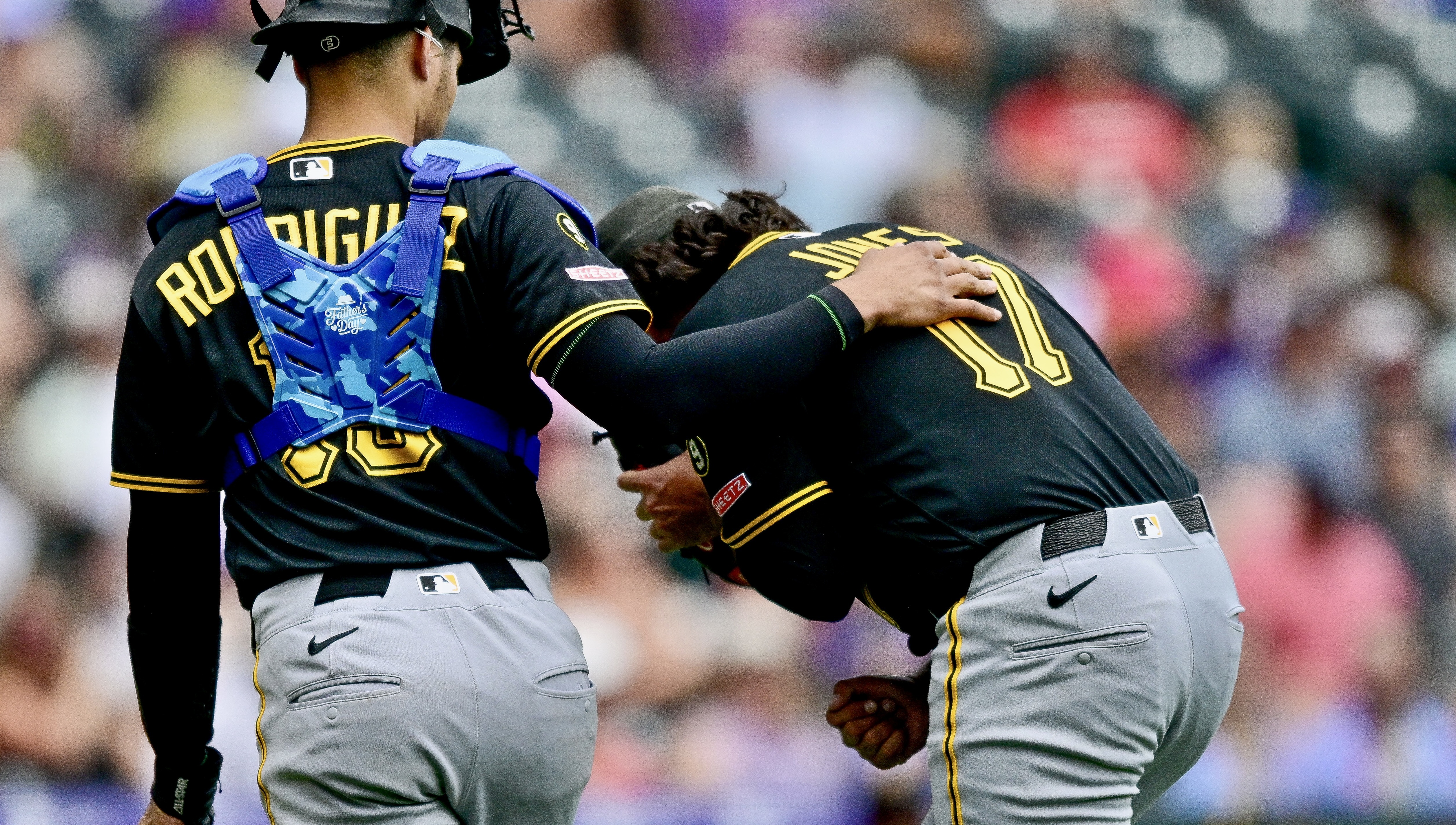 Jared Jones buckles over in pain after being struck by a line drive Sunday in Denver.