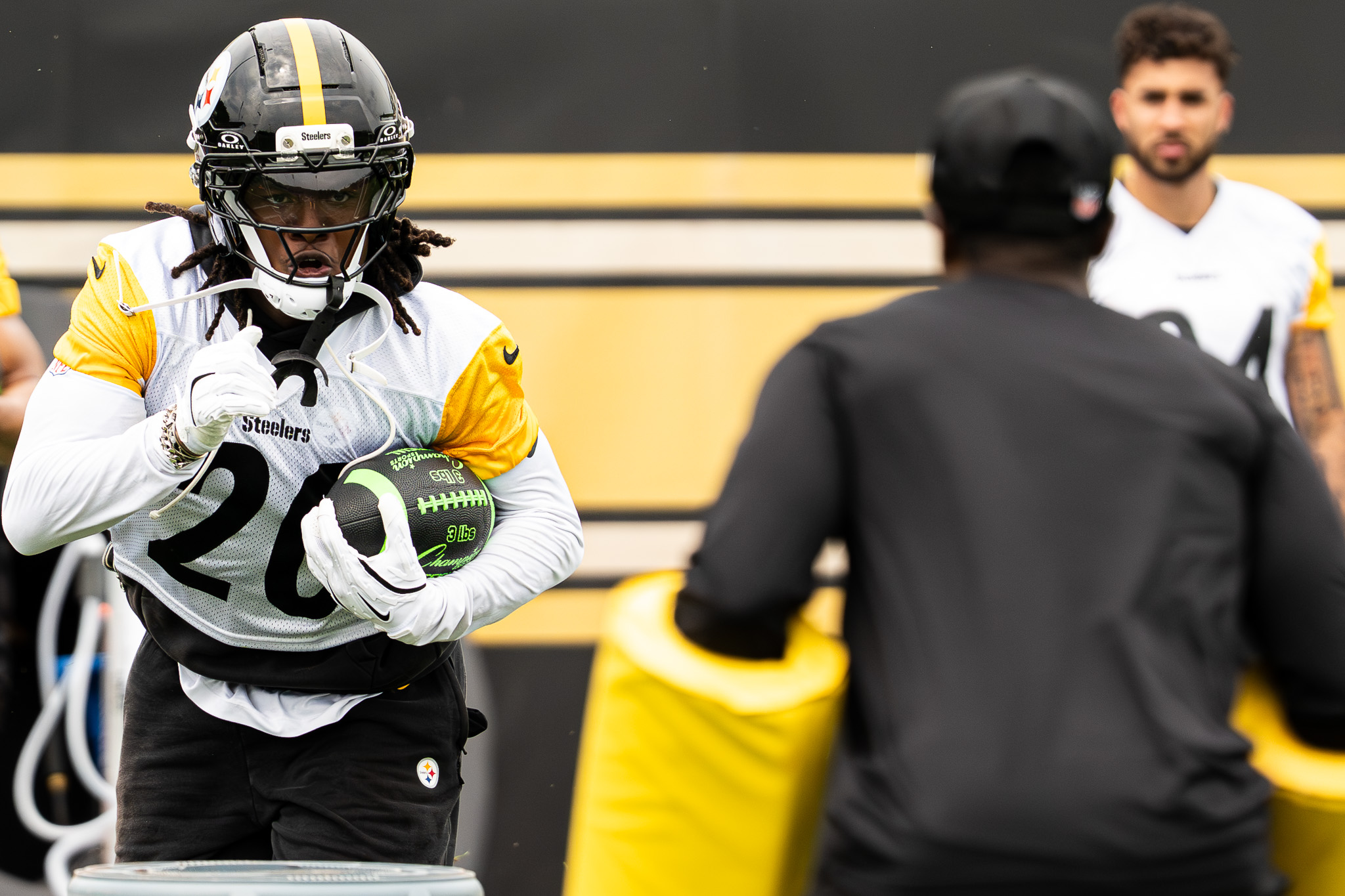 Kaleb Johnson runs toward a team staffer during running back drills. 
