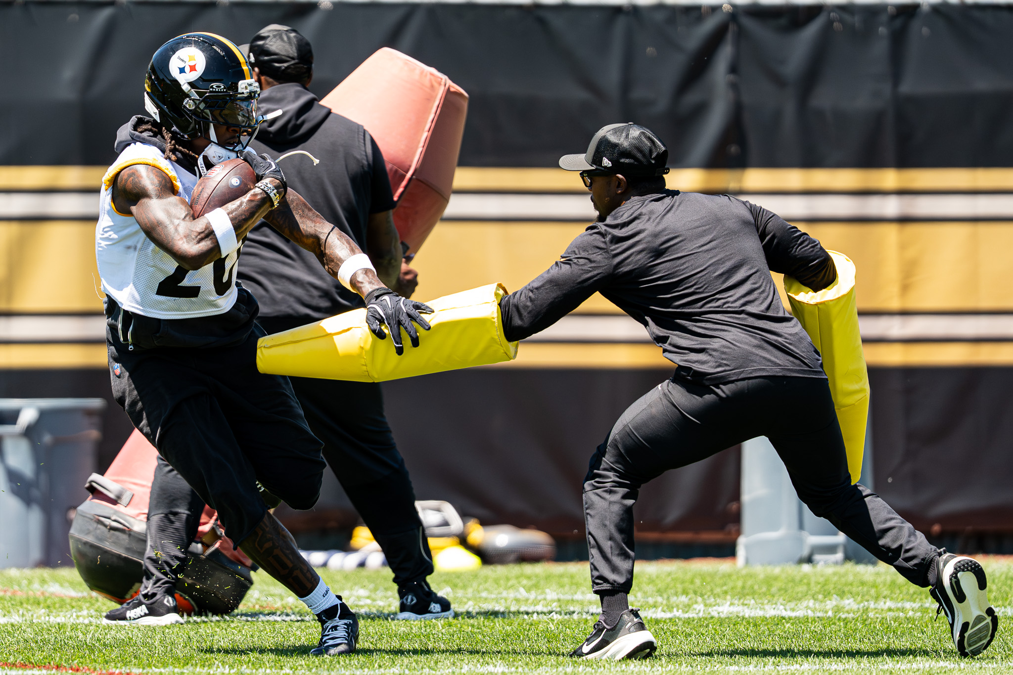 Kaleb Johnson stiff arms a pad held by a team staffer. 