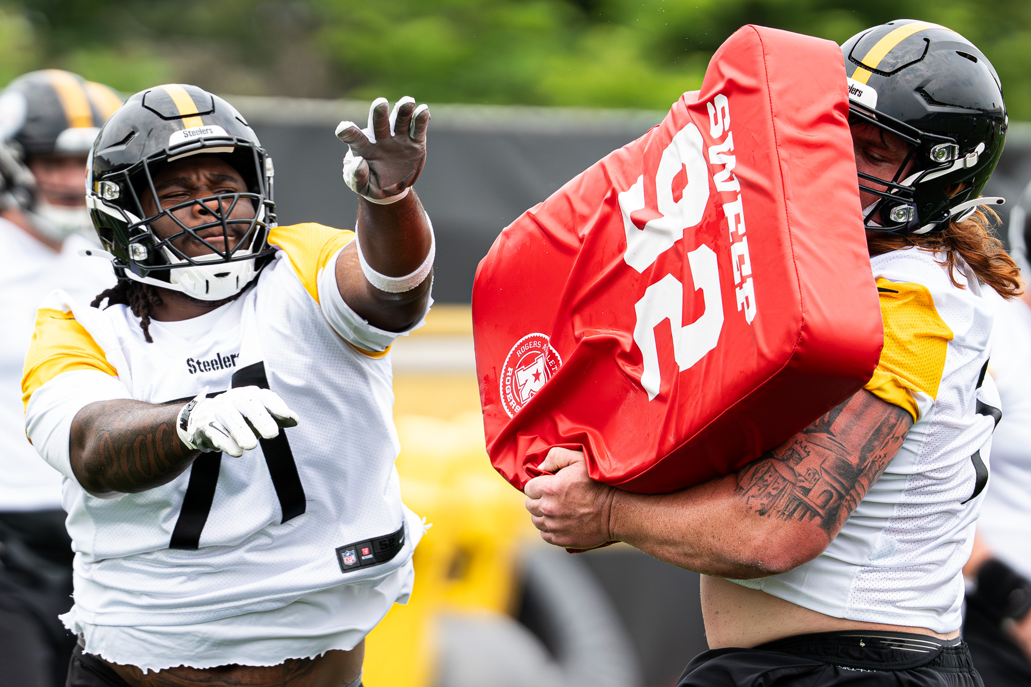 Max Iheanachor throws a blocking bad held by Gennings Dunker during a offensive line drill at the UPMC Rooney Sports Complex on Tuesday. 