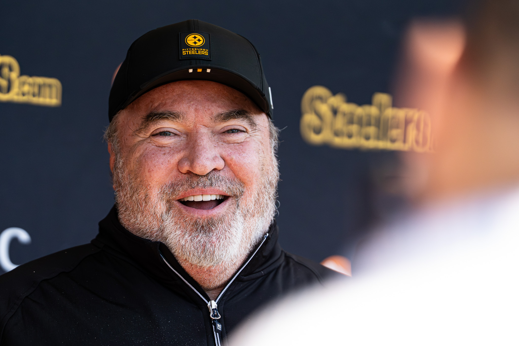 Mike McCarthy laughs after being asked a question during a pre-practice press conference.