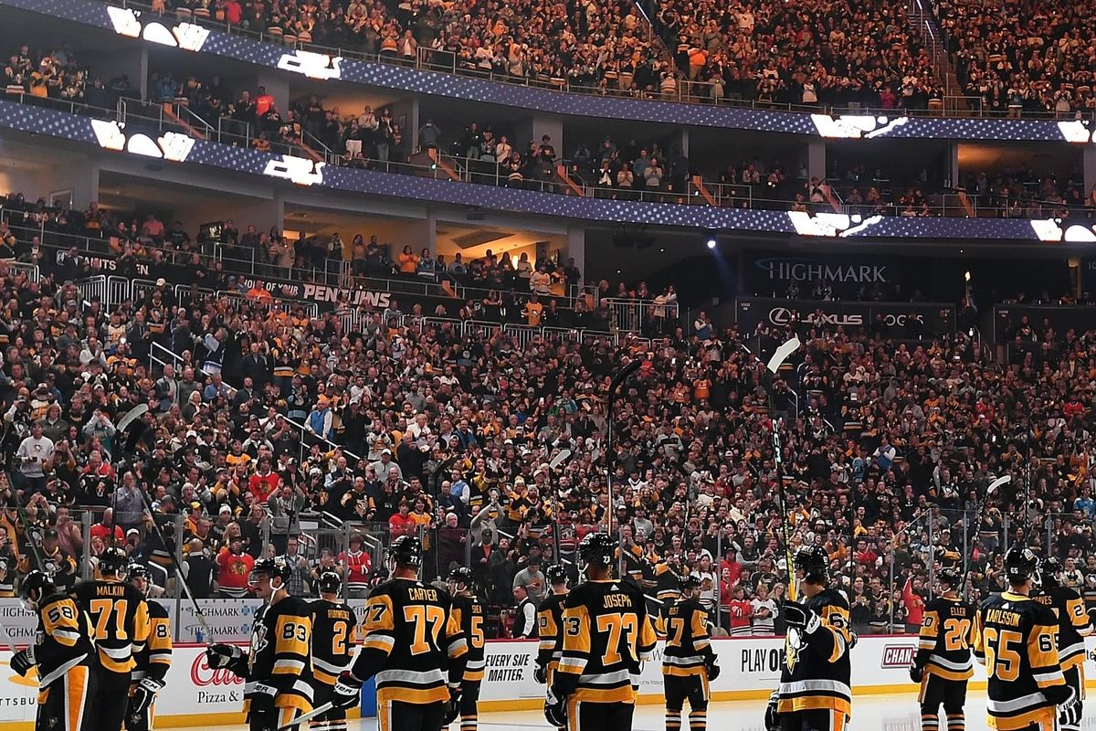 The Penguins stand in a circle at center ice after pregame introductions.